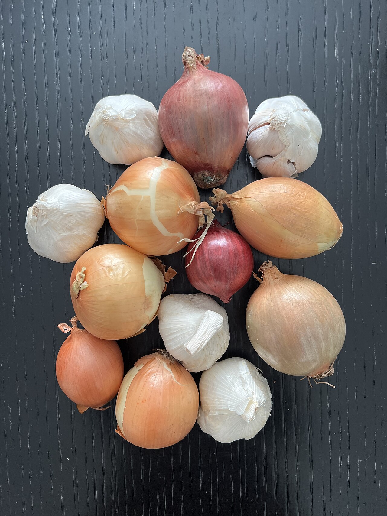 Raw brown onions and garlic bulbs on a table, foods toxic to dogs and cats